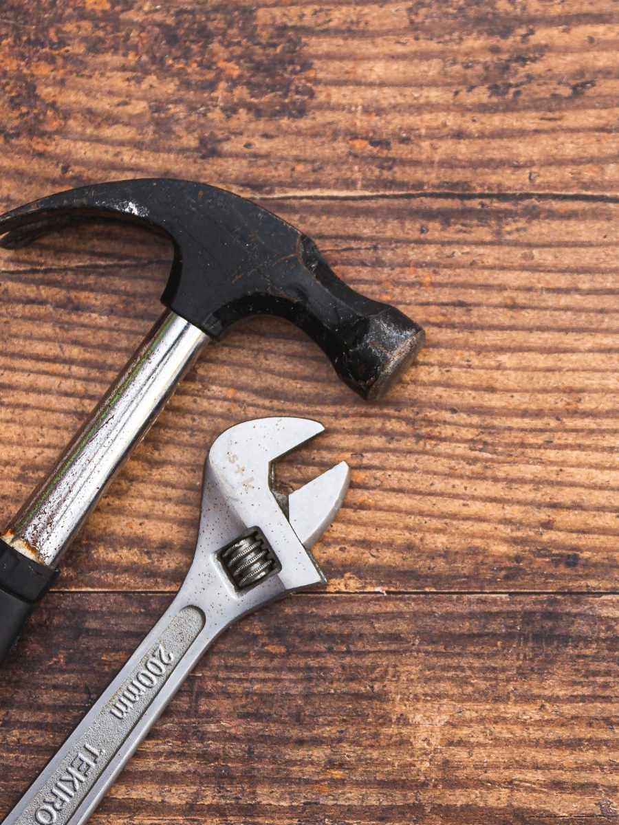 image of a hammer and wrench on a wooden table